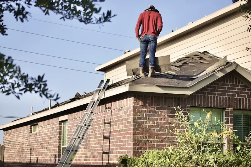 Professional roofer working on a residential roof in Saline